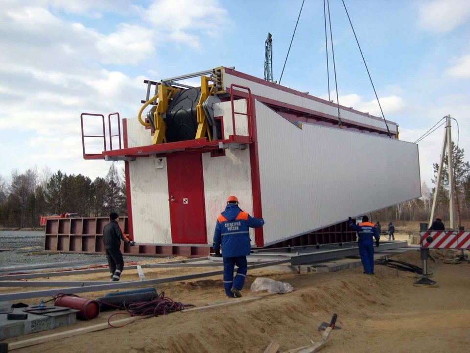 Tecwill modular concrete batching plant module being lifted into position on site using cranes, with installation crew guiding the placement.